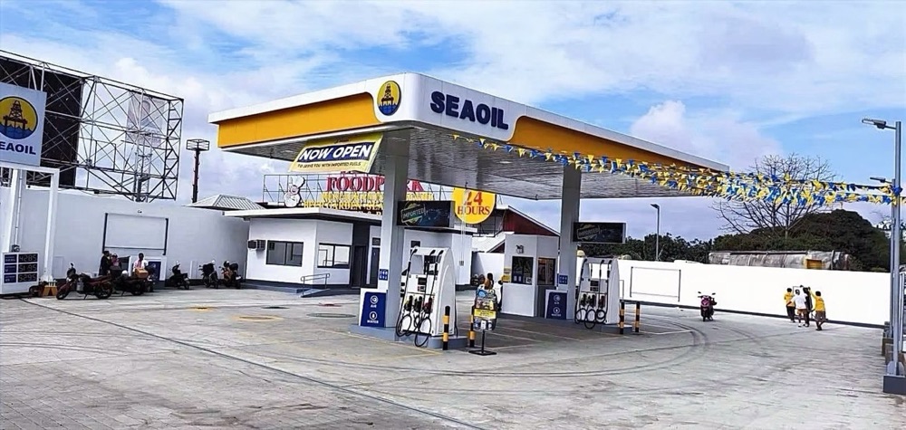 Completed station with bunting strung across the forecourt for its opening, the canopy and pumps beneath.