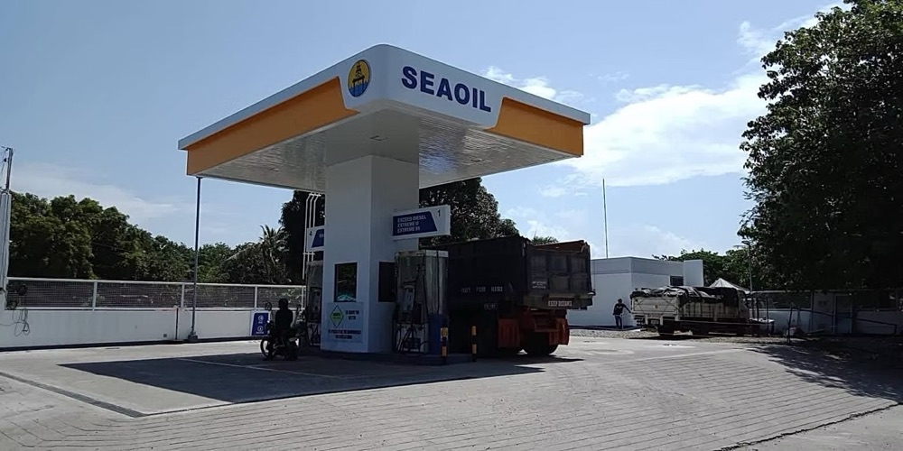 Completed station under a wide sky: canopy and dispenser island, with a truck at the pumps.