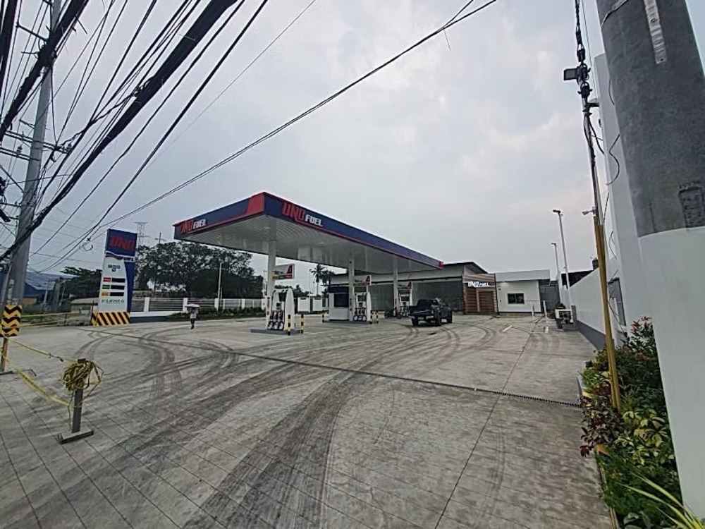 Completed station on a bend, its canopy and dispenser island seen from the approach road.